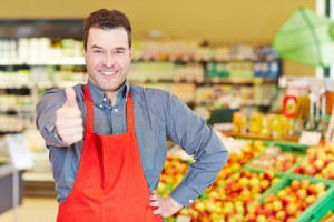 29682812 - happy salesman congratulates with his thumbs up in a supermarket